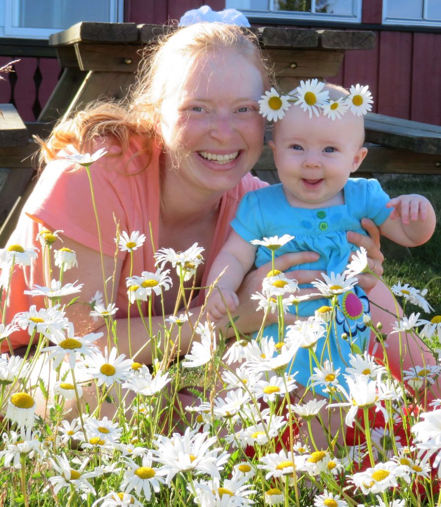 Image of Ashley and baby LJ in a daisy patch